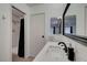 Bright bathroom featuring a white vanity, black fixtures, and tiled shower at 3018 Burnham Ave, Las Vegas, NV 89169