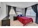 Cozy bedroom featuring wood-look flooring, large windows, and a plaid bedspread at 3018 Burnham Ave, Las Vegas, NV 89169