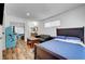 Bedroom with a bed, couch, wood floors, arcade game, and lots of light at 3018 Burnham Ave, Las Vegas, NV 89169