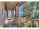 Covered porch with wooden railing, posts, and a view of greenery at 3018 Burnham Ave, Las Vegas, NV 89169