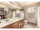 Bright bathroom with dual sinks, white cabinets, and shower with curtain at 307 Oak Canyon Dr, Henderson, NV 89015