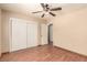 Unfurnished bedroom with wood floors, double closet doors, and ceiling fan at 307 Oak Canyon Dr, Henderson, NV 89015