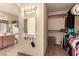 Walk-in closet featuring wood floors and shelves leading to the bathroom at 307 Oak Canyon Dr, Henderson, NV 89015