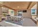 Spacious covered patio with a dining table, mounted TV, and stylish rug at 3217 Bonassola Ave, North Las Vegas, NV 89031