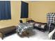 Simple bedroom setting, features yellow walls, checkered table, and a single bed at 3217 Bonassola Ave, North Las Vegas, NV 89031
