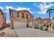 Two-story house featuring a stone facade, spacious driveway, a balcony, manicured landscaping, and a three-car garage at 3217 Bonassola Ave, North Las Vegas, NV 89031