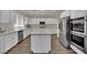 Spacious kitchen with white cabinetry, stainless steel appliances, an island, and hardwood floors at 3217 Bonassola Ave, North Las Vegas, NV 89031