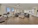 Open-concept living room featuring hardwood floors, neutral paint, a large sofa, and a view into the kitchen at 3217 Bonassola Ave, North Las Vegas, NV 89031