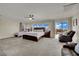 Spacious primary bedroom featuring carpet flooring, a ceiling fan, and private balcony access at 3217 Bonassola Ave, North Las Vegas, NV 89031