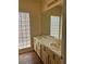 Bathroom with double sinks, neutral-colored counters, and backsplash plus a mosaic block window at 3394 Brookfield Dr, Las Vegas, NV 89120