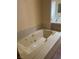 Large jacuzzi tub with tiled surround, gold-toned faucet and jets, perfect for unwinding in style at 3394 Brookfield Dr, Las Vegas, NV 89120