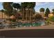 Picturesque water feature with mature trees, desert landscaping, and a tranquil pond creating a serene outdoor setting at 3394 Brookfield Dr, Las Vegas, NV 89120