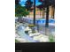 Resort-style pool area with a beautiful rock waterfall and lush landscaping creating a tranquil oasis at 3394 Brookfield Dr, Las Vegas, NV 89120