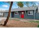 Cozy single-story home with gray siding, white trim and a bright red front door at 3412 Tabor Ave, North Las Vegas, NV 89030