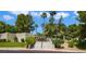 Community entrance featuring a stepped walkway leading to a secure gate, surrounded by lush greenery and palm trees at 3553 Kensbrook St, Las Vegas, NV 89121