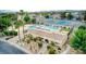 Aerial view of a community pool and tennis courts surrounded by lush greenery and palm trees at 3553 Kensbrook St, Las Vegas, NV 89121