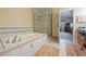 Well-lit bathroom with a glass-enclosed shower, tile surround tub, and tile flooring at 3640 E Vineyard Dr, Pahrump, NV 89048