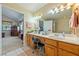 Spacious bathroom featuring double sinks with vanity lighting and access to the main bedroom at 3640 E Vineyard Dr, Pahrump, NV 89048