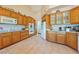 Bright kitchen with wooden cabinetry, tile floor, white appliances and lots of counterspace at 3640 E Vineyard Dr, Pahrump, NV 89048