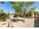 Backyard featuring mature trees, gravel landscaping, and covered patio at 368 Umbria Way, Henderson, NV 89014