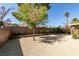 Large backyard featuring gravel, lush trees, and perimeter brick walls at 368 Umbria Way, Henderson, NV 89014