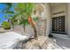 Close up of the double door home entrance with stone pillars and a well manicured palm tree at 3728 Richard Allen Ct, Las Vegas, NV 89147