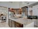 Bright kitchen with granite counters, center island with cooktop, stainless appliances, and dark wood cabinetry at 3728 Richard Allen Ct, Las Vegas, NV 89147