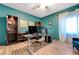 Office with wood floors, accent wall, custom bookshelves, and multiple monitors on an adjustable desk at 3728 Richard Allen Ct, Las Vegas, NV 89147