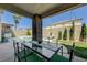 Covered patio with dining set and backyard pool in a lush outdoor setting at 3728 Richard Allen Ct, Las Vegas, NV 89147