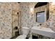 Stylish powder room with butterfly wallpaper, modern sink, gold accents, and unique shelving at 3728 Richard Allen Ct, Las Vegas, NV 89147