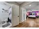 Open doorway to a bedroom with wood floors next to a bathroom with a toilet and shower curtain at 3928 Edgemoor Way, Las Vegas, NV 89121