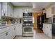 Well-lit kitchen features white cabinets, stainless steel appliances, and stone countertops at 3928 Edgemoor Way, Las Vegas, NV 89121