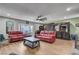 Comfortable living room with plush red sofas, a ceiling fan, and an entertainment center at 3928 Edgemoor Way, Las Vegas, NV 89121