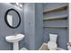 Modern half bathroom with a pedestal sink, decorative shelves, and a toilet at 4063 Lower Saxon Ave, North Las Vegas, NV 89085