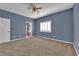 Neutral-toned bedroom featuring plush carpeting, ceiling fan and shuttered window at 4063 Lower Saxon Ave, North Las Vegas, NV 89085