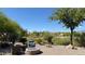 Relax in the serene backyard featuring a cozy fire pit, desert landscaping, and comfortable seating at 4299 Fiore Bella Blvd, Las Vegas, NV 89135