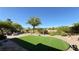 Inviting backyard with artificial grass, desert landscaping, and comfortable seating area at 4299 Fiore Bella Blvd, Las Vegas, NV 89135