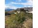 Desert landscaping surrounds a Southwest-style home with a mountain backdrop under a partly cloudy sky at 4299 Fiore Bella Blvd, Las Vegas, NV 89135