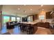 Spacious living room featuring an eat-in kitchen island, stainless appliances, and large windows at 4299 Fiore Bella Blvd, Las Vegas, NV 89135