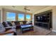 Inviting living room with ceiling fan, sectional sofa, large windows, and built in entertainment center at 4299 Fiore Bella Blvd, Las Vegas, NV 89135