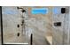 Modern shower featuring marble-patterned walls, sleek fixtures, and a comfortable built-in bench at 4299 Fiore Bella Blvd, Las Vegas, NV 89135