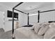 Stylish bedroom featuring a four-poster bed, mounted TV, and soft lighting at 4428 Mural Glen Ct, North Las Vegas, NV 89084