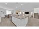 Open-concept kitchen with a large island, stainless steel sink, adjacent dining area, and staircase at 4428 Mural Glen Ct, North Las Vegas, NV 89084
