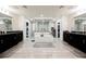 Bright bathroom with dual vanities, soaking tub, and separate shower, featuring elegant tile and lighting fixtures at 4576 Amazing View St, Las Vegas, NV 89129