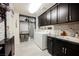 Well-organized laundry room with gray cabinets, a granite countertop, and a front-load washer and dryer at 4576 Amazing View St, Las Vegas, NV 89129