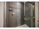 A tiled shower with a glass door, a handheld shower head, and vertical accent tiles at 4576 Amazing View St, Las Vegas, NV 89129