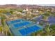 Aerial view of a community clubhouse, pool, tennis courts, and lush landscaping at 52 Reverie Heights Ave, Henderson, NV 89011
