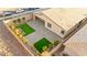 Aerial view of a modern backyard with pavers, green turf, desert landscaping and a covered patio at 52 Reverie Heights Ave, Henderson, NV 89011