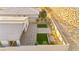 Aerial view of a modern backyard with pavers, green turf, desert landscaping and a block fence at 52 Reverie Heights Ave, Henderson, NV 89011