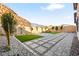 Landscaped backyard features lush green grass, concrete pavers, gravel and a retaining wall at 52 Reverie Heights Ave, Henderson, NV 89011